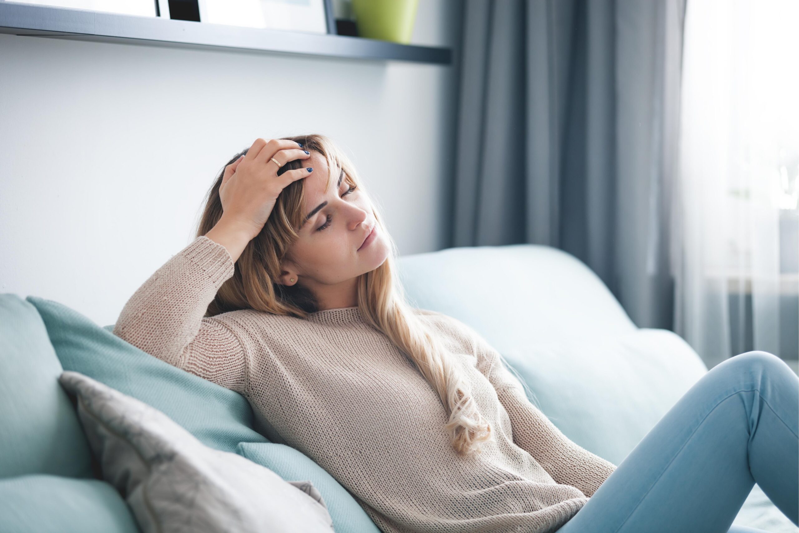 girl sitting on couch with head in hand