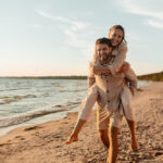 leisure and people concept - happy couple having fun on summer beach